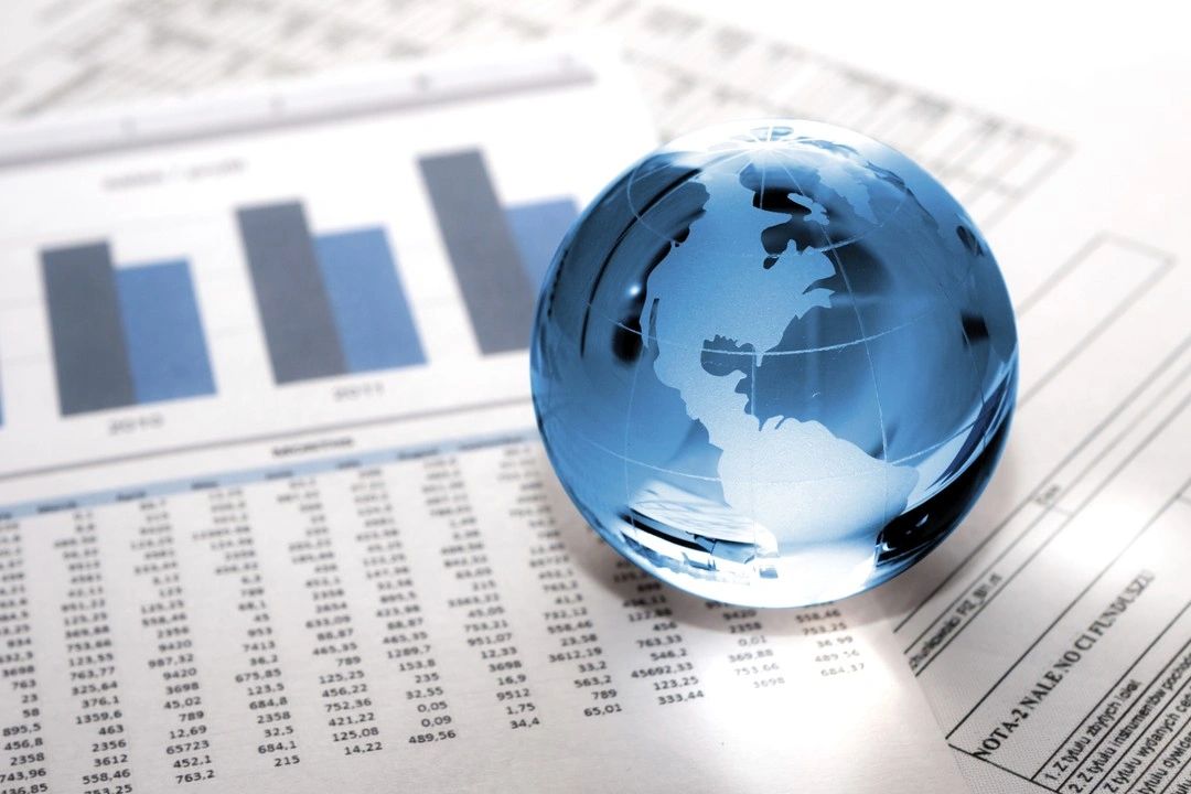 Glass globe resting on financial charts and figures